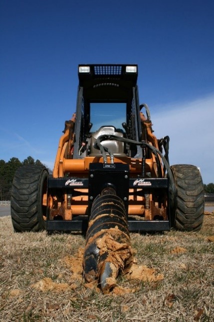 ) skid-steer loader with an earth auger attachment